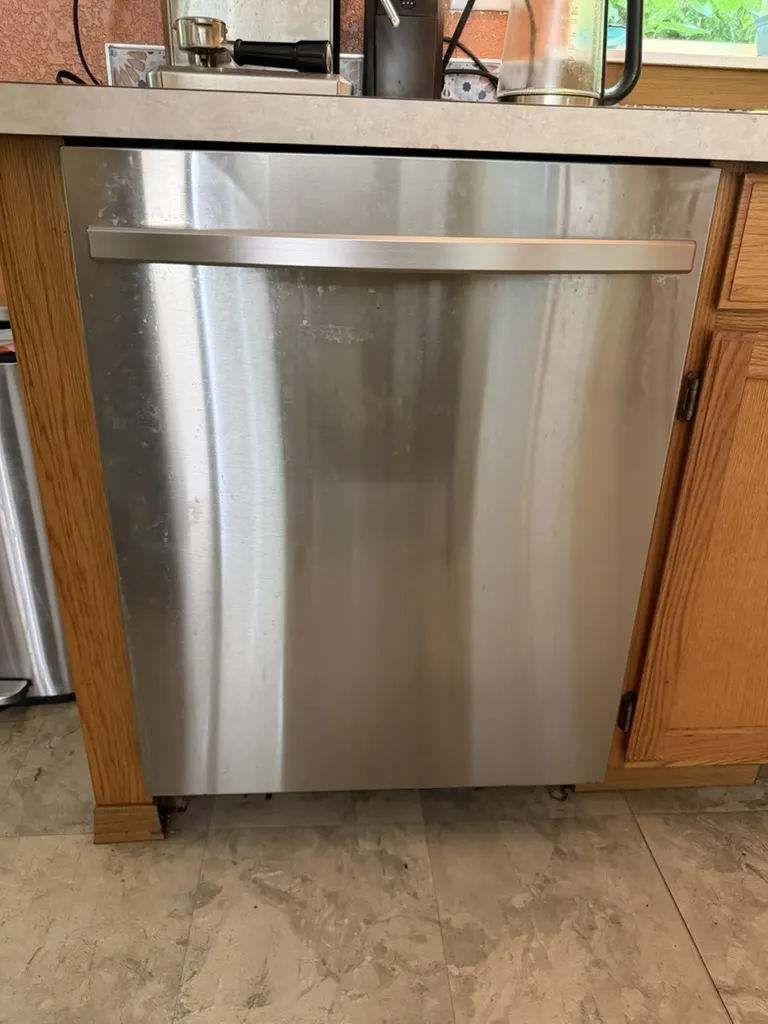 Stainless steel dishwasher installed in a kitchen before FixPro drainage diagnosis