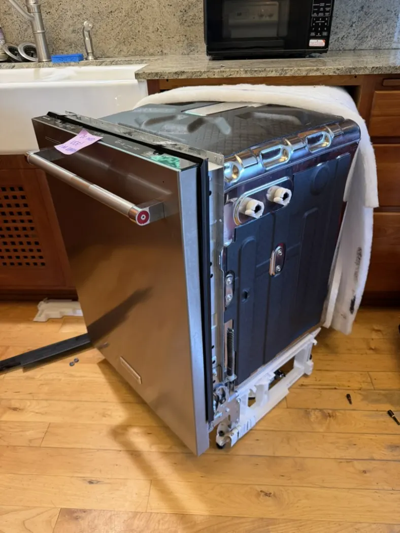 Built-in dishwasher removed from the cabinet for professional access to its rear and underside