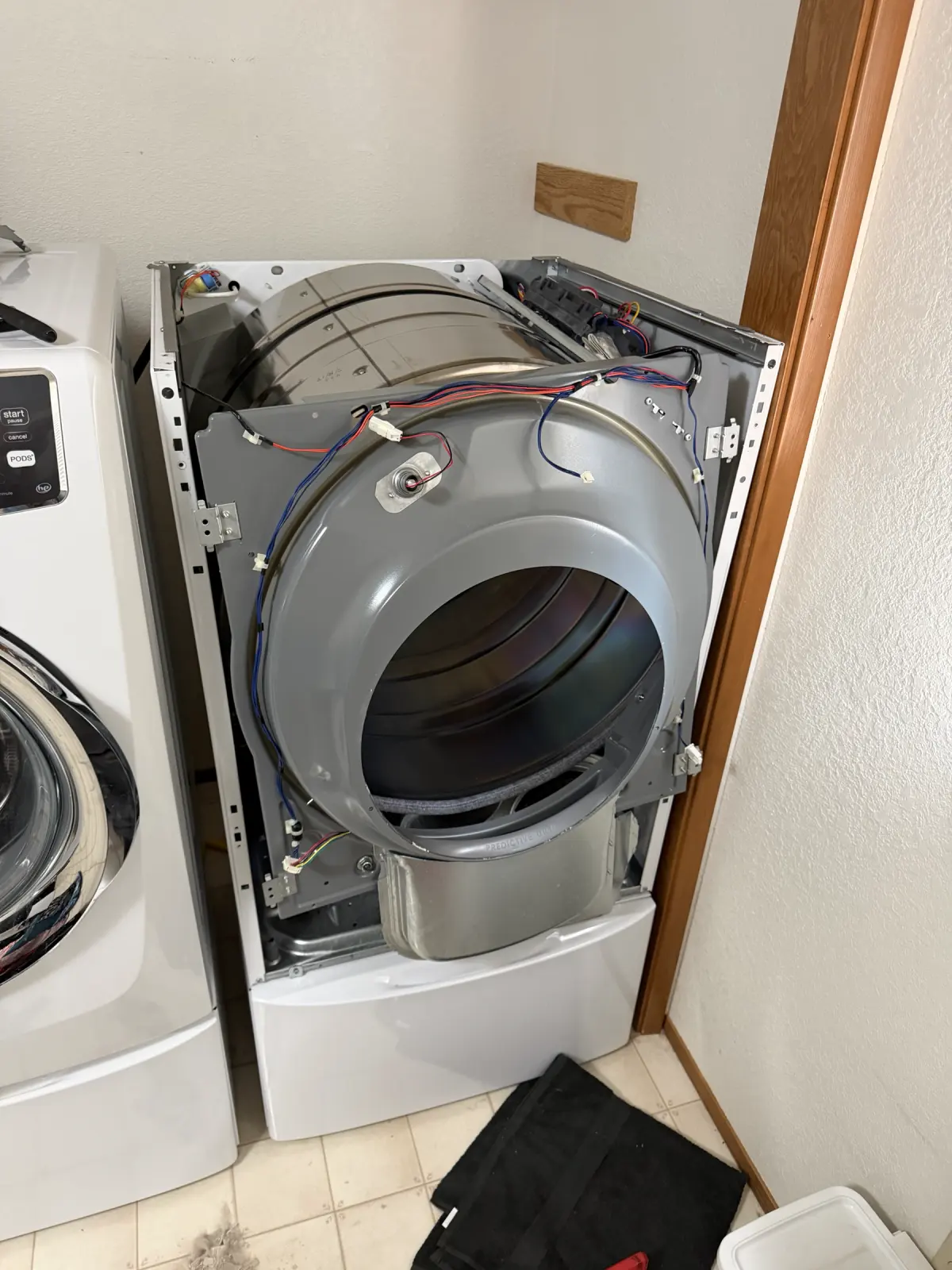 Dryer with the front panel removed showing the drum, wiring harness, and cabinet assembly