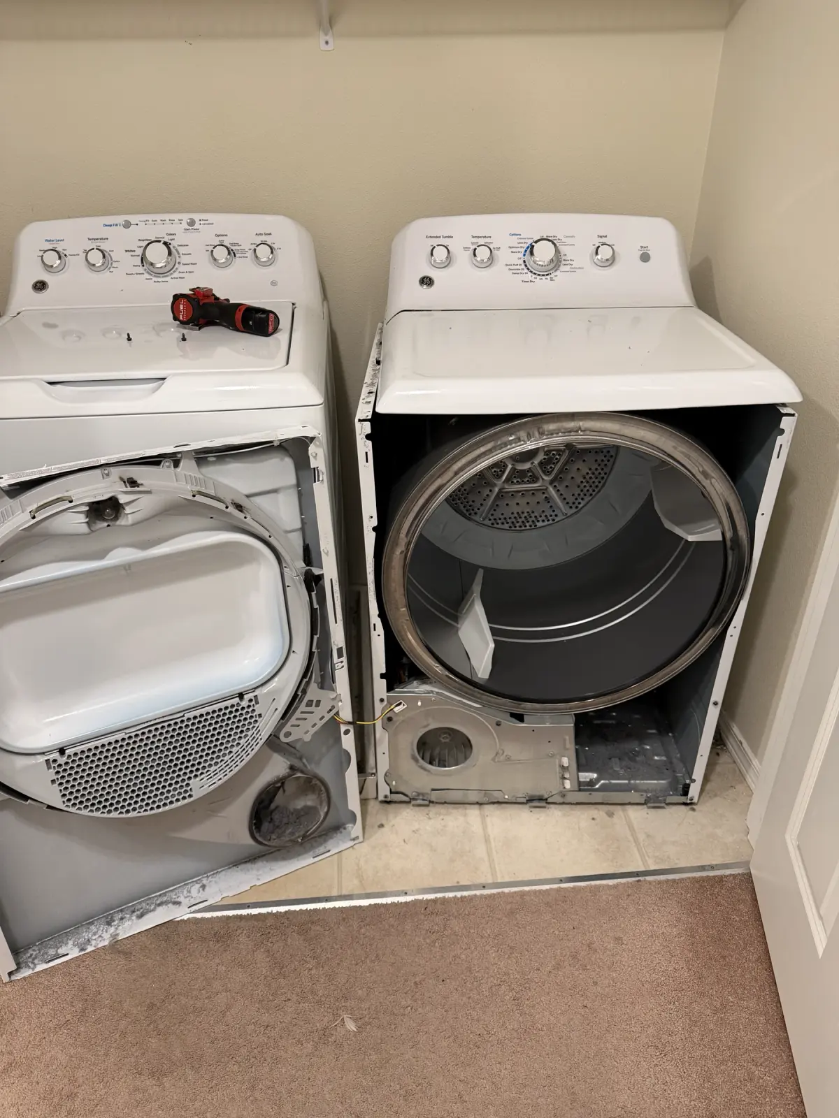 Two residential dryers opened during FixPro diagnosis with the drum and cabinet components exposed