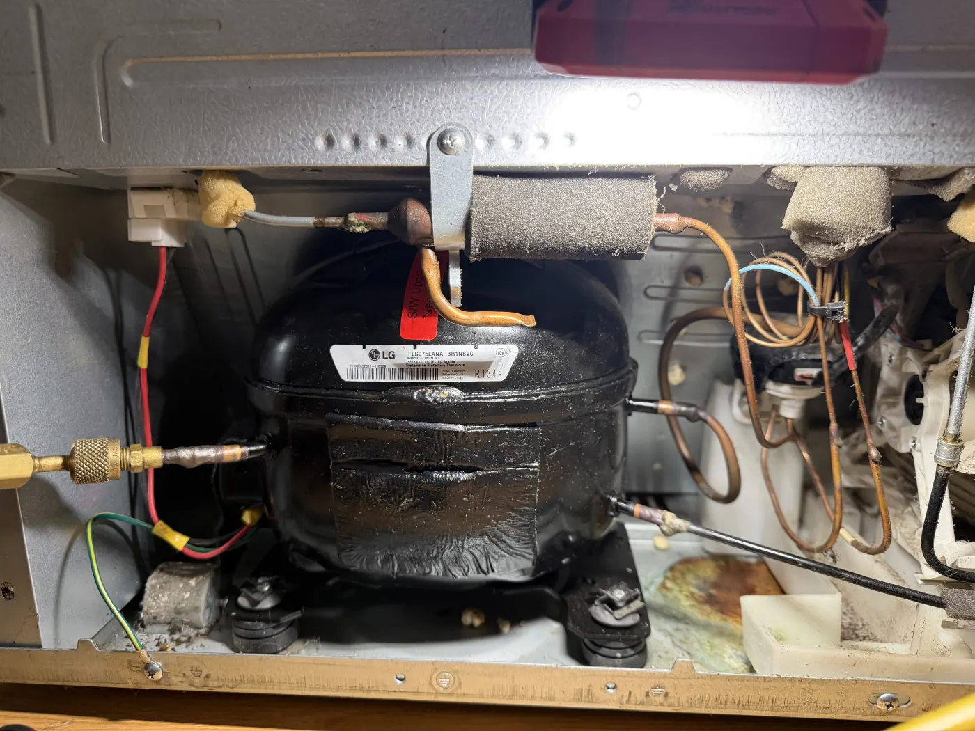 Refrigerator compressor compartment opened for professional noise diagnosis