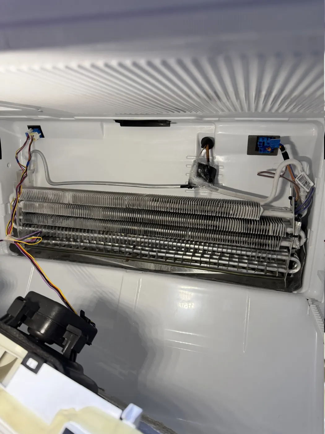 Refrigerator evaporator and airflow components exposed during service