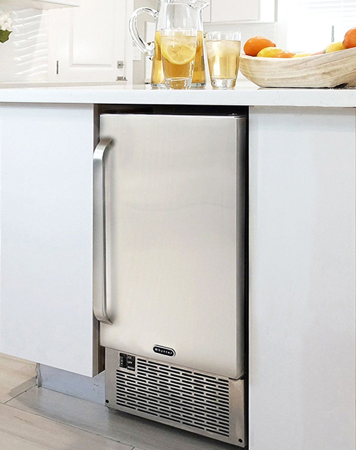 Stainless steel undercounter ice maker installed in a home kitchen